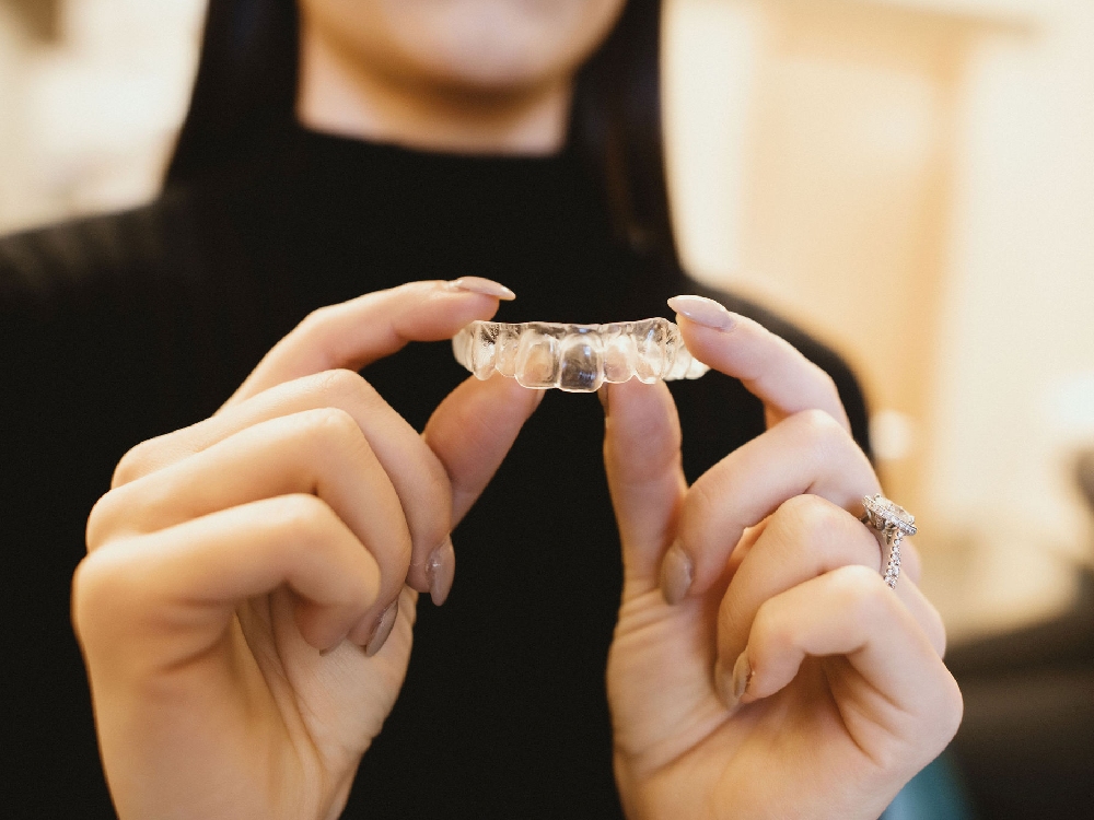 A patient holds a retainer